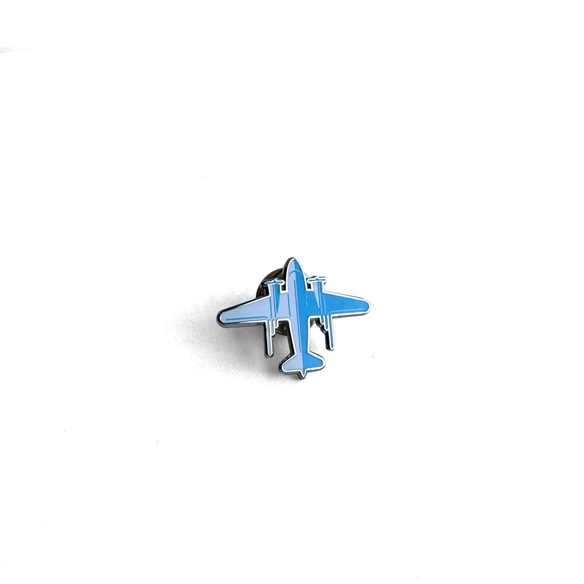 DC-3 Lapel Pin featuring a stylized aircraft design in bright blue and silver tones against a white background, showcasing The Roasterie's iconic vintage aircraft in miniature enamel form