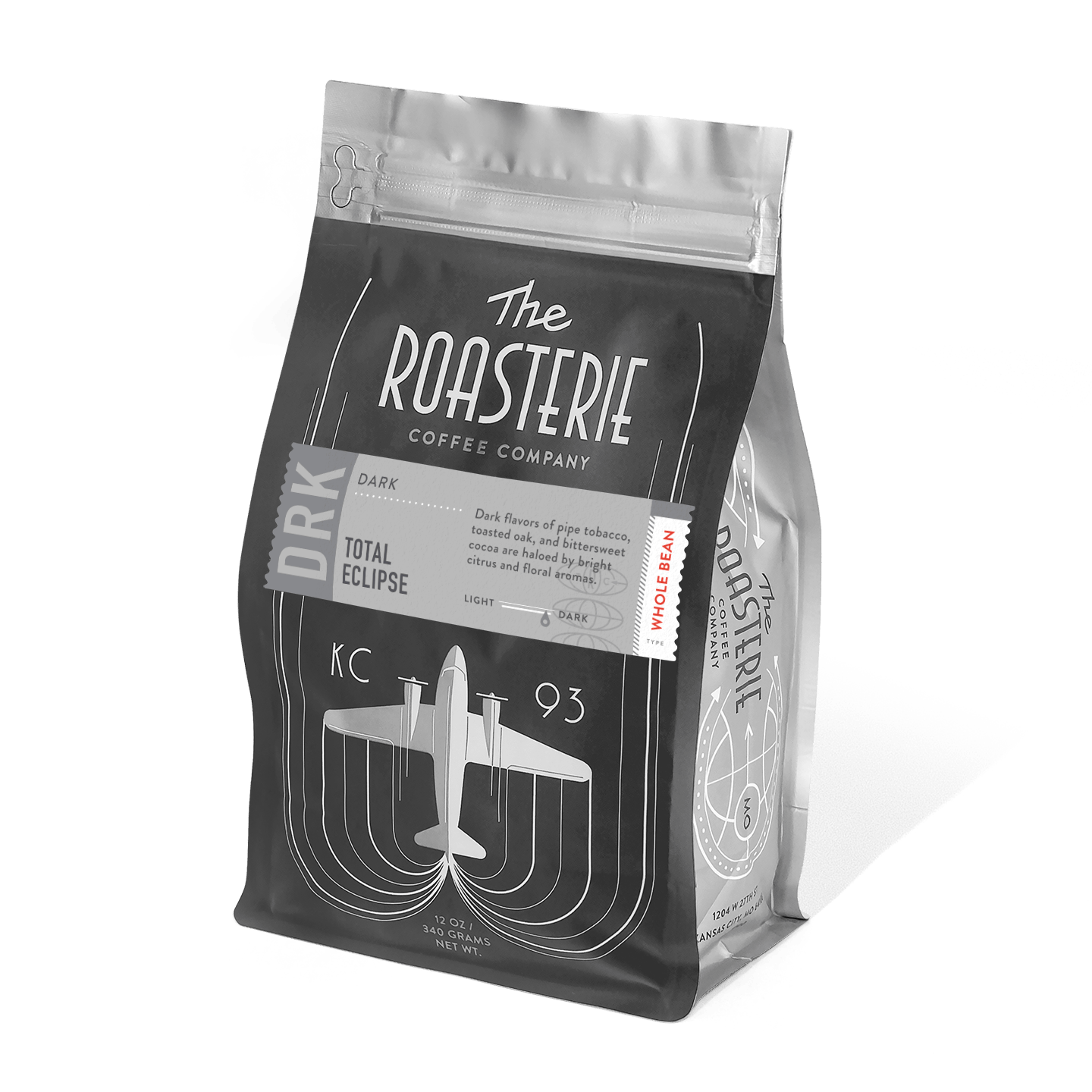 A black and silver coffee bag of Total Eclipse by The Roasterie featuring art deco-inspired design with a vintage airplane motif and concentric curves, showcasing their dark roast blend with a resealable top on a matte finish package
