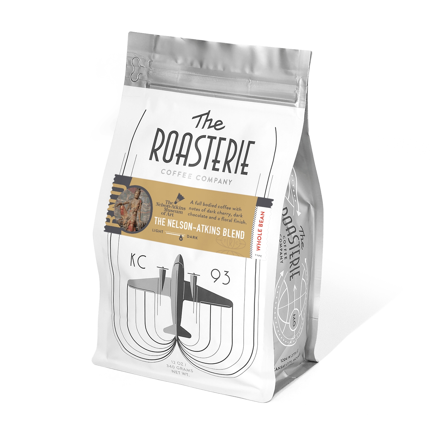 The Nelson-Atkins Blend coffee bag from The Roasterie featuring white packaging with black art deco-style airplane design and gold accent band showcasing museum artwork inspiration