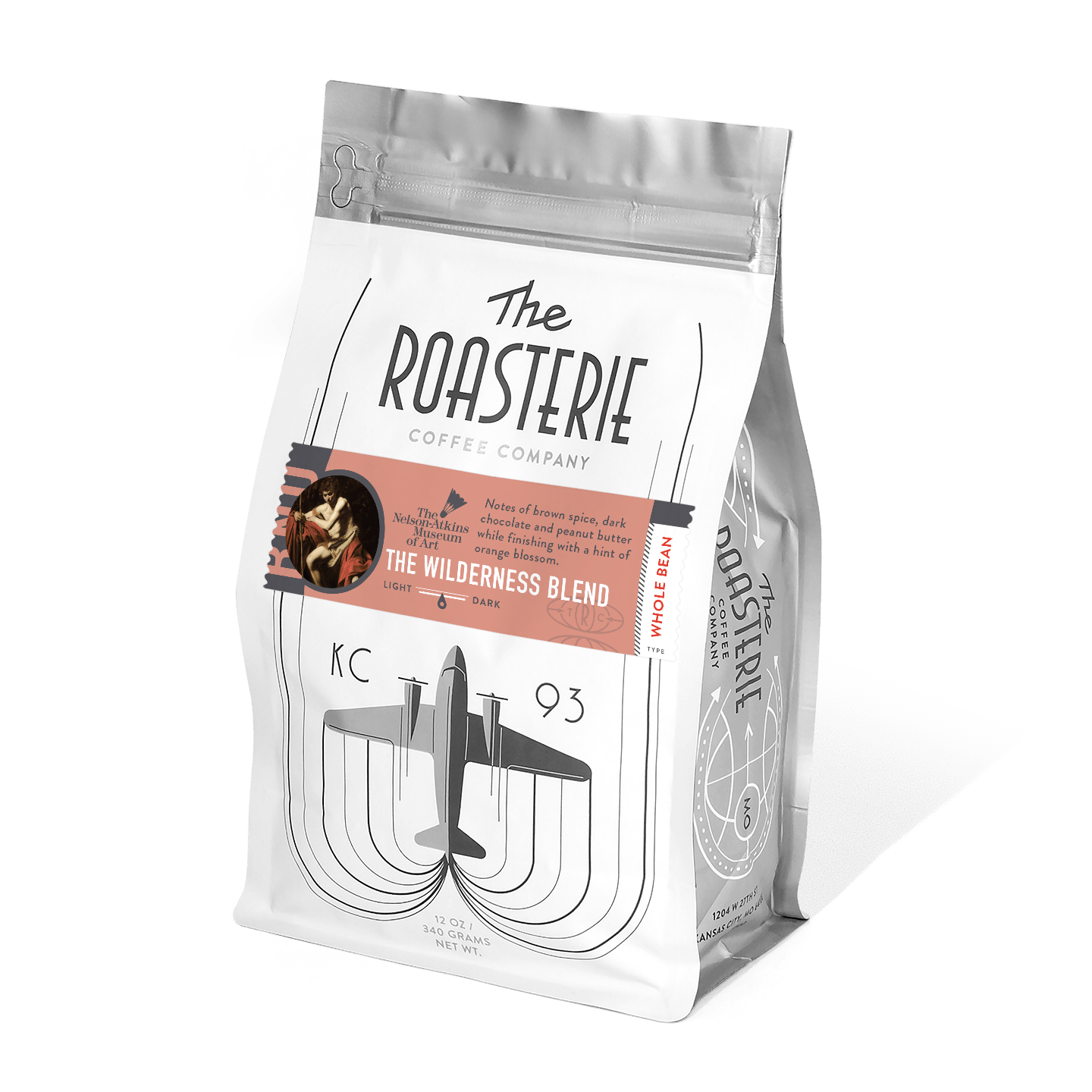 The Wilderness Blend coffee bag from The Roasterie, featuring an art-inspired design with a vintage aircraft illustration and coral-colored label. The premium coffee packaging showcases elegant typography and a resealable silver pouch for freshness.